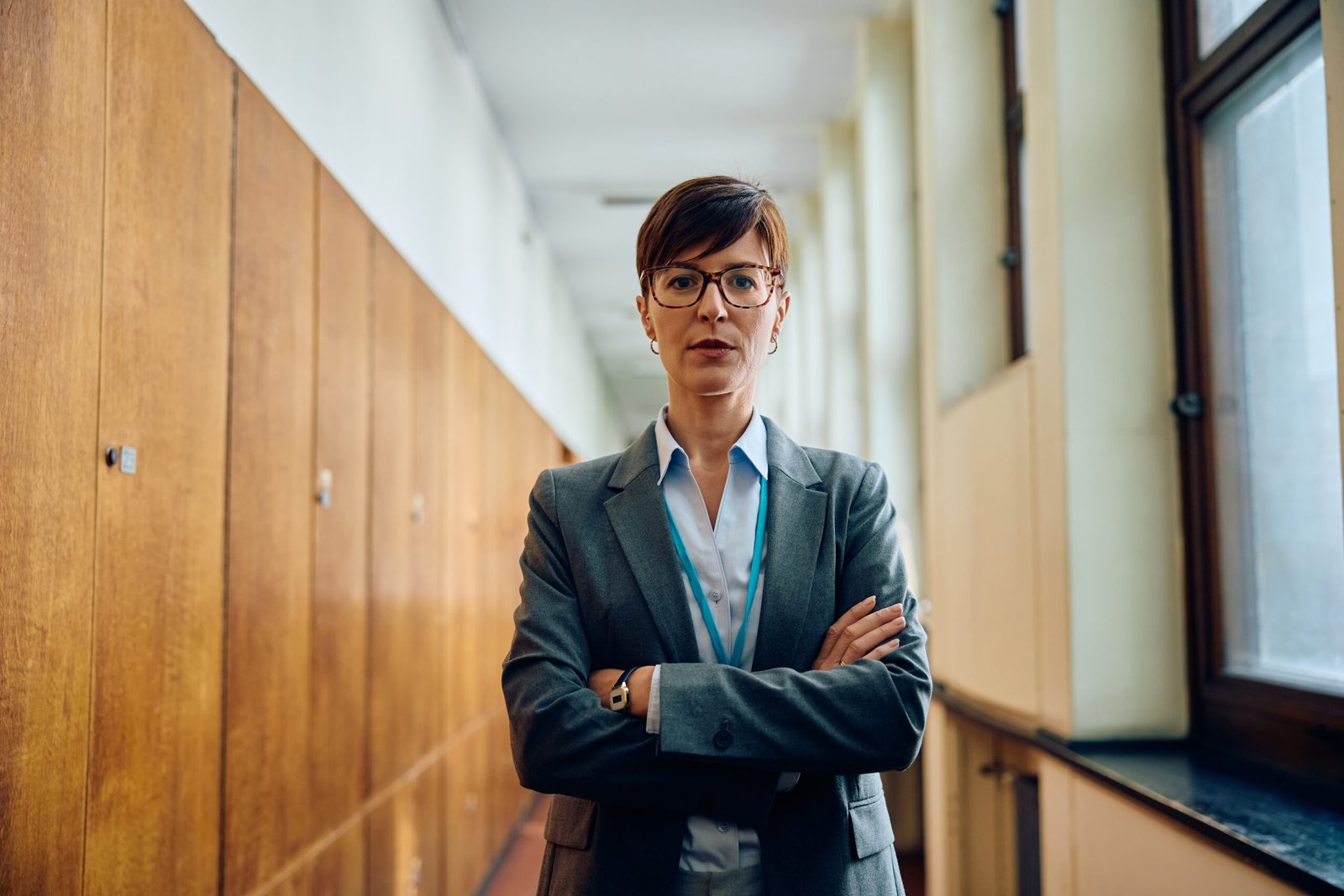 Portrait of high school teacher standing with her arms crossed and looking at camera.